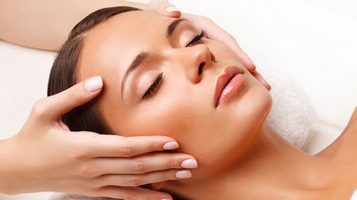 Esthéticienne réalisant un soin du visage dans un institut de beauté